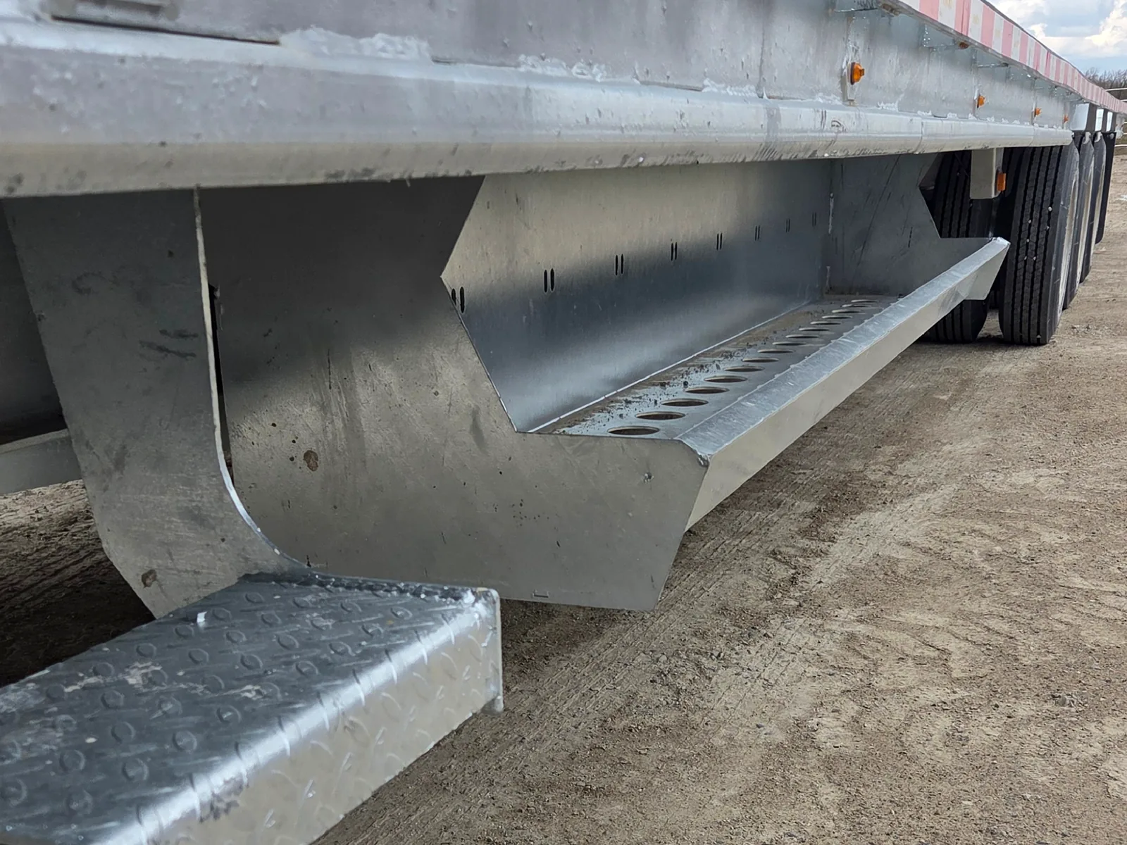 Integrated dunnage storage box beneath a flatdeck trailer