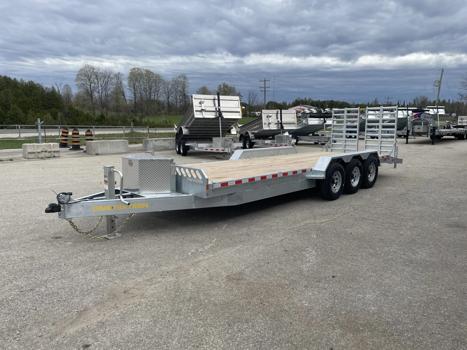 Galvanized tri-axle low profile equipment hauler with stand-up ramps and front toolbox