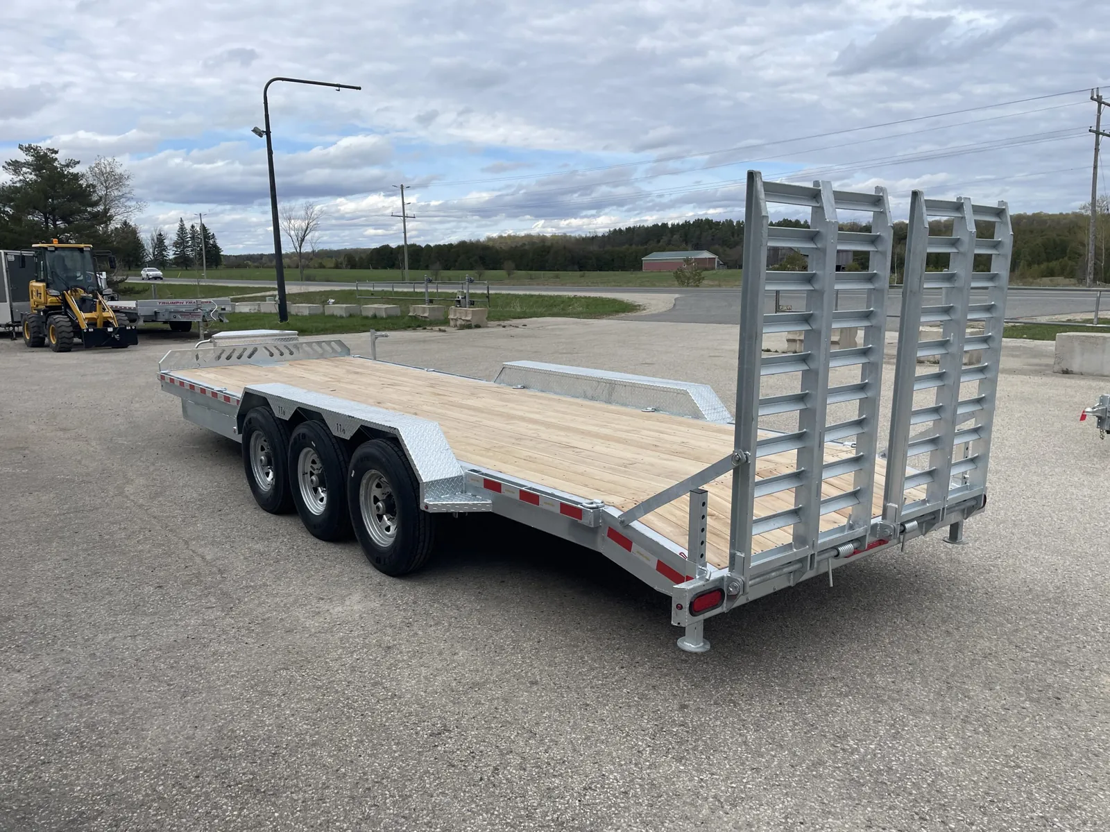 Tri-axle equipment hauler from the rear, ramps standing up